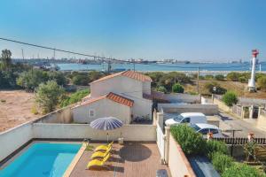 ein Haus mit Pool und Sonnenschirm in der Unterkunft Appartement de 3 chambres avec vue sur la mer piscine privee et terrasse amenagee a Port de Bouc a 5 km de la plage in Port-de-Bouc