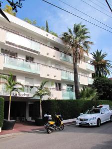 a motorcycle and a car parked in front of a building at Appartement moderne à Antibes - 50 m² - Vue sur jardin in Antibes