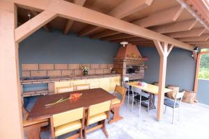 an outdoor kitchen with a wooden table and chairs at Charming Apartment in Prazeres with Shared Pool - 150 m² in Campanário