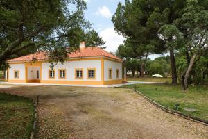 a large yellow house with trees in the background at Sunny Villa in Comporta with Private Pool in Montalvo