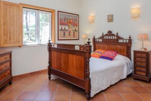 a bedroom with a large wooden bed and a window at Sunny Villa in Comporta with Private Pool in Montalvo +40 photos
