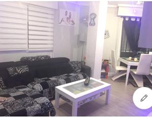 a living room with a couch and a table at 3 bedrooms apartement with city view jacuzzi and furnished terrace at Almeria 2 km away from the beach in Almería