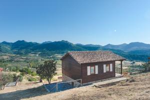 a small house on a hill with mountains in the background at Charming House Cañamero + Pool in Cañamero