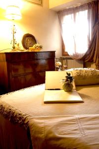 um computador portátil sentado em cima de uma cama em 2 bedrooms house with city view jacuzzi and enclosed garden at Massa e Cozzile em Massa e Cozzile