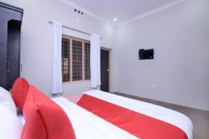 - un lit rouge et blanc dans une chambre avec fenêtre dans l'établissement Wayal Wayanad Twin Villa, à Panamaram