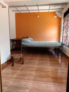 um quarto com uma cama no canto de um quarto em Hanakodu homestay em Sringeri