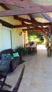 a patio with a couch under a wooden roof at Villa de 4 chambres avec piscine privee et jardin amenage a Monbazillac in Monbazillac