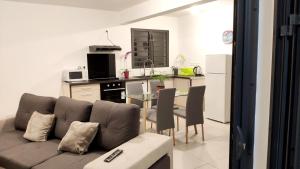 Una sala de estar con un sofá y una mesa con sillas. en Appartement charmant à Saint Pierre 44 m² avec jardin clôturé, en Saint-Pierre