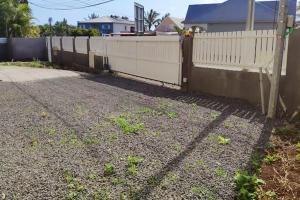 una valla frente a una casa con entrada en Appartement charmant à Saint Pierre 44 m² avec jardin clôturé, en Saint-Pierre 1 foto más