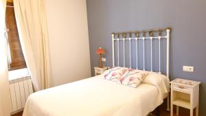 a bedroom with a bed with white sheets and pink pillows at Charming villa in Pajares de la Lampreana with private pool in Pajares de la Lampreana +11 photos