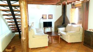 a living room with two chairs and a tv at 3 bedrooms villa with private pool enclosed garden and wifi at Pajares de la Lampreana in Pajares de la Lampreana