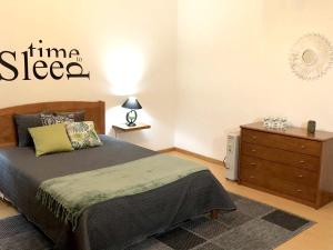 a bedroom with a bed and a dresser at Comfortable House in Ribeira Grande, Pleasant Garden in Ribeira Grande