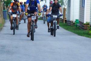 a group of people riding bikes down a street at Bungalow with Shared Pool in Pataias + 30 m² + Pool. in Pataias