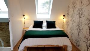 a bedroom with a bed with a green and white blanket at Maison charmante avec vue sur la mer à Locquirec in Locquirec
