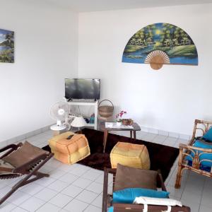a living room with chairs and a flat screen tv at Appartement de 2 chambres avec vue sur la mer et jardin clos a Le Moule a 1 km de la plage in Le Moule