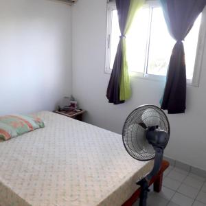 a bedroom with a fan next to a bed at Appartement de 2 chambres avec vue sur la mer et jardin clos a Le Moule a 1 km de la plage in Le Moule