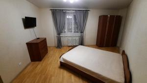 a small bedroom with a bed and a window at комфортная 2 комнатная квартира возле Аквапарка на Комсомольской 148 in Ufa