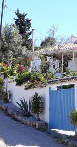 una casa blanca con una puerta azul y plantas en 3 bedrooms house with private pool enclosed garden and wifi at Los Romanes, en Benamargosa