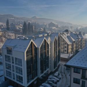 a group of buildings with snow on the roofs at Baza Smart Hotel in Bukovel