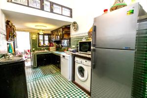 cocina con nevera y lavadora en 3 bedrooms apartement with private pool enclosed garden and wifi at Fes en Fez