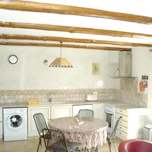 cocina con mesa y sillas en una habitación en Maison de 2 chambres avec piscine partagee jardin clos et wifi a Monteux, en Monteux