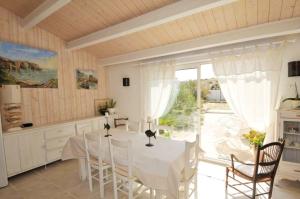 a kitchen with a table and chairs and a large window at Maison accueillante avec jardin, Sainte-Marie-de-Ré in Sainte-Marie-de-Ré