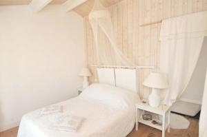 a bedroom with a white bed and two lamps at Maison accueillante avec jardin, Sainte-Marie-de-Ré in Sainte-Marie-de-Ré