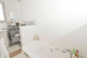 a white bathroom with a tub and a sink at Maison accueillante avec jardin, Sainte-Marie-de-Ré in Sainte-Marie-de-Ré +15 photos