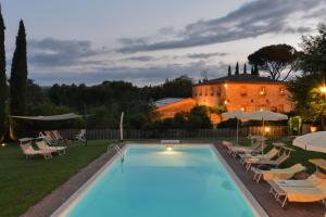 una piscina di fronte a una casa con sedie e un edificio di Luxurious Villa in Monteroni d'Arbia a Monteroni dʼArbia