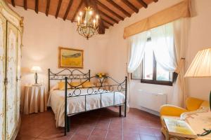 una camera da letto con un letto e un lampadario di Luxurious Villa in Monteroni d'Arbia a Monteroni dʼArbia Altre 31 foto