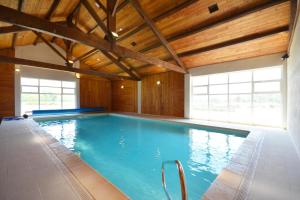 einen großen Pool in einem Zimmer mit Holzdecken in der Unterkunft Maison de 3 chambres avec piscine partagee jardin amenage et wifi a Saintes Maries de la Mer in Saintes-Maries-de-la-Mer