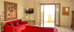 a living room with red furniture and a sliding glass door at Modern Apartment in Boca Chica, 130 m², Air Conditioning Included in Boca Chica