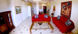 a living room with a red couch and a table at Modern Apartment in Boca Chica, 130 m², Air Conditioning Included in Boca Chica