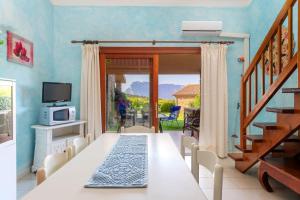 a dining room with a long table and a television at Spacious Apartment in San Teodoro with Garden and Parking in San Teodoro