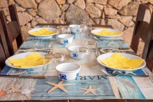 a wooden table with a blue and white table cloth with stars at Spacious Apartment in San Teodoro with Garden and Parking in San Teodoro +6 photos