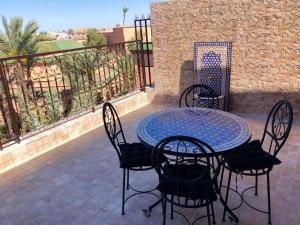 马拉喀什Charming Triplex in Annakhil, Marrakech with Shared Pool的带桌椅和栅栏的露台