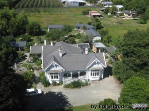 an aerial view of a large house with a yard at White Elephant Accomodation in Motueka