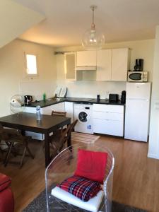 uma cozinha e sala de jantar com uma mesa com uma almofada vermelha em Appartement de 3 chambres avec jardin clos et wifi a Sannois em Sannois