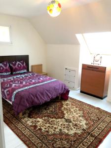 1 dormitorio con cama morada y alfombra en Appartement de 3 chambres avec jardin clos et wifi a Sannois, en Sannois
