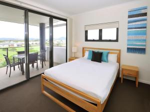 a bedroom with a bed and a balcony with a table at Apartments G60 Gladstone in Gladstone