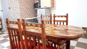 a wooden table and chairs in a kitchen at Modern apartment with balcony and mountain view in Souillac in Souillac
