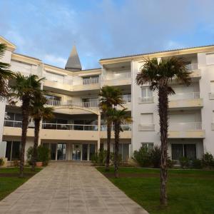 a large building with palm trees in front of it at Les Pins - 3 pièces - Vue sur piscine - 600m mer - Les Sables d'Olonne in Les Sables-dʼOlonne +33 photos
