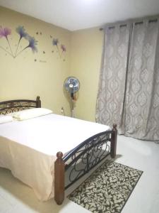 a bedroom with a bed and a window with flowers on the wall at 2 bedrooms apartement with furnished balcony at Mahebourg 1 km away from the beach in Mahébourg