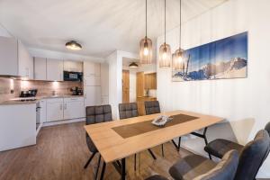 eine Küche und ein Esszimmer mit einem Holztisch und Stühlen in der Unterkunft AlpenParks Hotel & Apartment Hochkönig in Mühlbach am Hochkönig