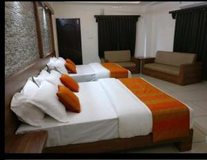 two beds in a hotel room with two bedsskirts at HISHAM SUITES in Ernakulam