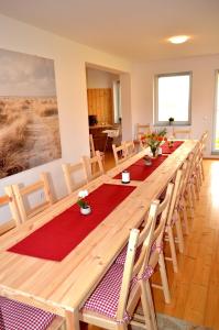 einen langen Holztisch in einem Zimmer mit Stühlen in der Unterkunft Ferienwohnung Klaus in Dolní Lánov