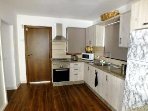 a kitchen with a sink and a stove top oven at La Cabaña in Guía de Isora