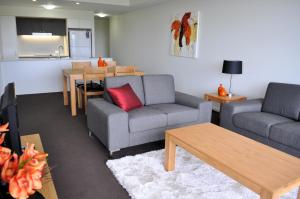 a living room with two couches and a kitchen at Apartments G60 Gladstone in Gladstone