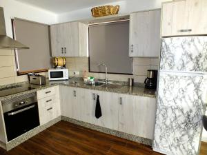 a kitchen with white cabinets and a sink at La Cabaña in Guía de Isora