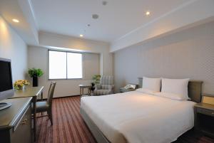
a hotel room with two beds and a table at International Garden Hotel Narita in Narita
